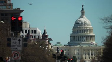 Washington, DC, ABD - 03: 21: 2025: Kırmızı ve yeşil trafik ışıkları yayalar yönlerini değiştirirken, Washington, DC 'deki ABD Kongre Binası açık bir gökyüzüne karşı belirgin bir şekilde ayakta duruyor.