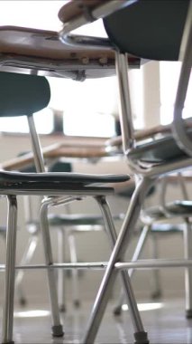 Dikey video masaları boş karanlık lise, orta ya da ilkokul sınıflarında pencerelerden ışık geliyor..