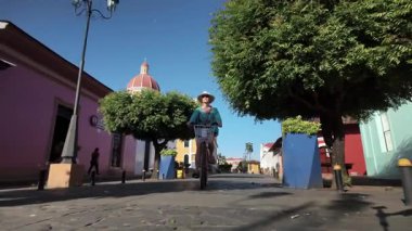 Bir turist, Katedral 'den bisiklet sürerken Nikaragua' nın canlı atmosferini tecrübe eder. Büyüleyici sokaklar yemyeşil ağaçlar ve tarihi binalarla dolu..