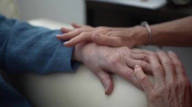 El masajı yapılıyor. Gerginliği azaltmak için avuç içi ve parmakları gevşetmeye odaklanıyor. Ortalık sakin ve huzurlu. Rahatlamak için ideal..