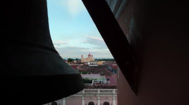 Gün batımında Granada Katedrali 'nin nefes kesici manzarası, çan kulesi tarafından çerçevelenmiş. Kilise kuleleri renkli gökyüzüne karşı aydınlanarak şehrin güzelliklerini gözler önüne seriyor..