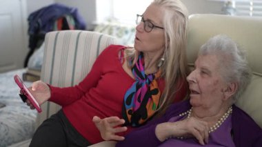 Yetişkin bir kız olarak iki nesil birbirine bağlanıyor. Yaşlı anne resimlerini telefonda gösteriyor. Yürekten bir anın tadını çıkarıyorlar, eski anıları yad ediyorlar..