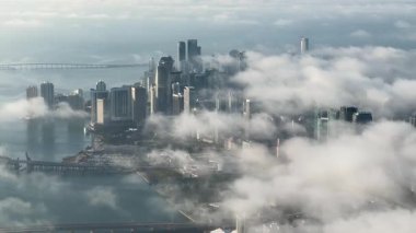 Miami, Florida 'nın dramatik hava perspektifi. Bulutlarla örtülü uzun gökdelenler. Arka planda Atlantik Okyanusu parıldıyor, sakin bir manzara yaratıyor..