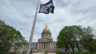 Batı Virginia Eyalet Kongresi Charleston 'da görkemli bir şekilde duruyor, çarpıcı mimarisini sergiliyor yemyeşil ve sallanan bir eyalet bayrağı arasında..
