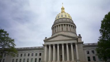 Ziyaretçiler, Charleston 'daki Batı Virginia Eyalet Kongre Binası' nın muhteşem mimarisine hayran kalarak, ikonik altın kubbesini ve klasik sütunlarını bulutlu bir gökyüzüne karşı sergilediler..