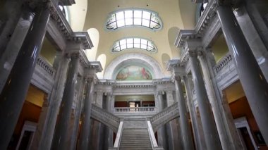 Kentucky Eyalet Meclisi 'nin çarpıcı iç mimarisi karmaşık bir duvar resminin altında büyük merdiven ve mermer sütunlar sergiliyor. Önemli bir hükümet sitesi.