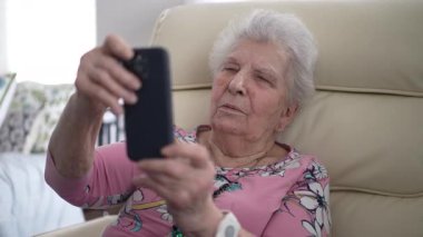 Yaşlı bir kadın koltuğunda rahat bir şekilde oturur, telefonuyla neşeli bir görüntülü konuşma yapar, sevdikleriyle anılarını paylaşır..