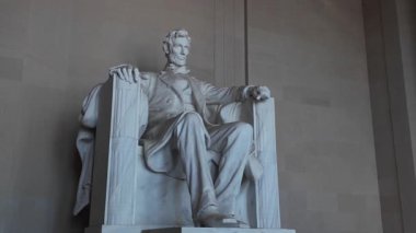 Washington DC 'deki Lincoln Anıtı' nın yakın görüntüsü. Mermer heykel Abraham Lincoln 'ü bir sandalyede otururken ve elleri kolçakların üzerinde dinlenirken tasvir ediyor..
