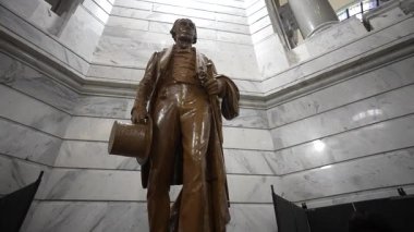 Frankfort, KY, ABD - 04 28 2025: Henry Clay 'in heykeli Kentucky Eyalet Meclis Binası' nda belirgin bir şekilde duruyor, karmaşık mermer iç mekanı gözler önüne seriyor ve eyaletlerin yasama organlarını yansıtıyor.