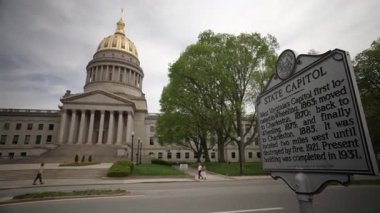 Charleston, WV, ABD - 04 22 2025: Ziyaretçiler Charleston 'daki Batı Virginia Eyalet Meclisi' nin çarpıcı mimarisine hayran kalarak, görkemli kubbesini ve eyalet meclisi yakınlarındaki zengin tarihini sergilediler..