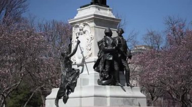 Marquis de Lafayette 'in heykeli Lafayette Meydanı' nda belirgin bir şekilde duruyor. Yakındaki ağaçlar çiçek açıyor ve Washington DC 'de gökyüzü açık mavi..