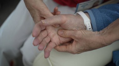 Bir çift el yakın planda gösteriliyor, rahatlamış bireylerin parmaklarına rahatlatıcı bir masaj yapıyor, seans boyunca bakım ve sükuneti vurguluyor..