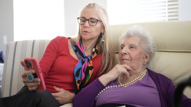 Olgun bir kadın, sıcak ve sevgi dolu bir ziyaret sırasında aile albümlerinin anılarını ve anlarını paylaşan yaşlı annesiyle meşgul olur..