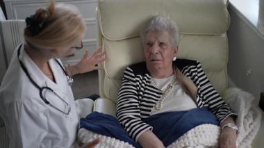 Bir bakıcı, evinde yaşlı bir kadına kişisel ilgi gösteriyor. İkisi bir an için sağlık ve refah üzerine konuşuyorlar..