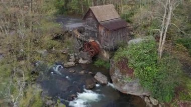 Batı Virginia 'nın Appalachian arazisinin ortasındaki derenin oluşturduğu Babcock Eyalet Parkları ikonik yay değirmenini çevreleyen canlı bahar renklerine bakın..