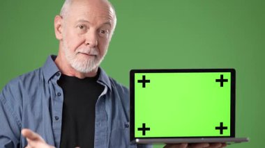 Orta yaşlı bir adam elinde yeşil ekranlı bir laptop tutarken gülümsüyor. Dijital projeler için mükemmel, sade yeşil bir zemine sahip..