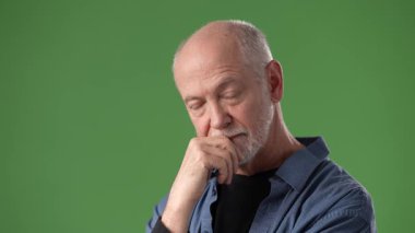 Sakallı olgun bir adam sıradan bir gömlek giyerken iyi bir jest yapar. Yeşil ekran çeşitli kullanımlar için bir üniforma arkaplanı sağlar.