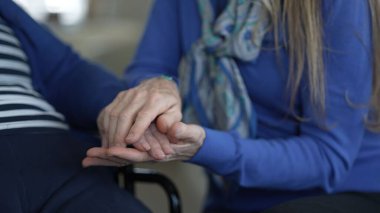 Doksanlı yaşlarındaki bir kadın, evine yaptığı samimi bir ziyaret sırasında kızından destek ve sevgi görüyor. Aralarındaki bağı ve bakımın önemini vurguluyor..