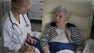 Bir bakıcı, evinde yaşlı bir kadına kişisel ilgi gösteriyor. İkisi bir an için sağlık ve refah üzerine konuşuyorlar..