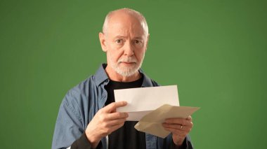 Katı yeşil bir zemine karşı durarak, yaratıcı bir ortamda çeşitli duyguları aktaran, sakallı, olgun bir kıdemli adamın POV 'u düşünceli bir şekilde hareket eder..