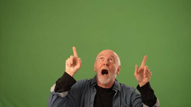 Olgun bir adam ellerini havaya kaldırarak coşku gösteriyor. Yüzünde şaşırmış bir ifade var..