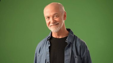 Düşünceli ve sıkıcı bir ifadeye sahip olgun bir adam katı yeşil perde arkasında duruyor. Elleri birbirine kenetlenmiş, derin düşüncelere ya da yansımaya işaret ediyor..