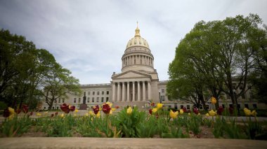 Charleston 'daki Batı Virginia Eyalet Meclisi' nde çarpıcı bir taş cephe ve baharda açan renkli laleler tarafından çerçevelenmiş seçkin bir altın kubbe yer alıyor..