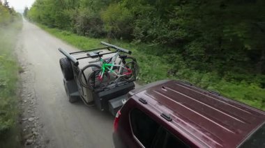 Aileler, maceralar için bisiklet parkında bisiklet parkında, gözyaşı damlalarıyla çakıllı bir yolda seyahat ederken kamp yolculuğunun keyfini çıkarırlar..