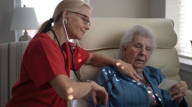 Bakıcı, yaşlı bir kadına rahat bir sağlık merkezinde hafıza görevinde yardımcı olur. Her ikisi de bir bağlantı ve bağlılık anını paylaşıyor.