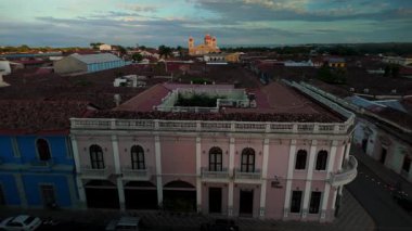 Granada, Nikaragua 'yı saran çarpıcı bir günbatımı, şehrin canlı tarihi binalarını ve arka plandaki önde gelen kiliseleri vurguluyor..