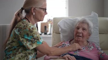 Hoş bir ziyaret sırasında, bir hemşire yaşlı bir kadının hayati organlarını kontrol eder ve huzur evinde neşeli bir konuşma yapar..