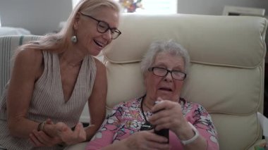 Gülümseyen bir kız, yaşlı annesine nasıl telefon edileceğini öğrenirken huzur evini ziyaret ederek, bağlantıyı ve hafızayı güçlendirir..