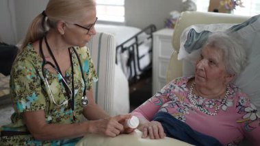 Hemşire, yaşlı bir kadının, huzur evinde arkadaşça sohbet ederken hayati organlarını kontrol ederken hoş bir etkileşim gerçekleşir..