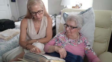 Bir huzurevinde, bir kız ve yaşlı annesi bir fotoğraf albümüne bakıp birlikte geçirdikleri zamanların tadını çıkarırken kahkahalarını ve anılarını paylaşıyorlar..
