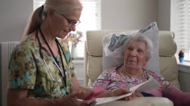 Hemşire, huzurevinde yaşlı bir kadının hayati organlarını kontrol eder. Arkadaşça sohbet yoluyla arkadaşlık ve yardım sağlar..
