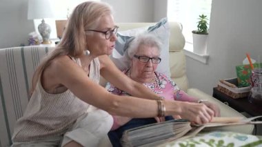 Rahat bir huzurevinde, bir kız ve yaşlı annesi çok sevilen bir fotoğraf albümünde gülümseyerek ve anılarını tazelerken....