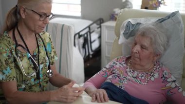 Dost canlısı bir hemşire yaşlı bir kadının hayati organlarını dikkatle kontrol eder. Huzur ve bakım sağlamak için huzurevinde sohbet ederler..