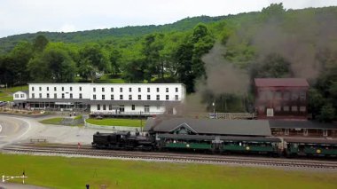 Batı Virginia, WV 'deki Cass State Park' ın genel hava görüntüsü. Shay motoru istasyonda ve buharlı trenle dağın zirvesine çıkmak için turistlerle dolu..