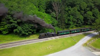 Hava kamerası siyah dumanın etrafında dönüyor tren raylarda ilerlerken..