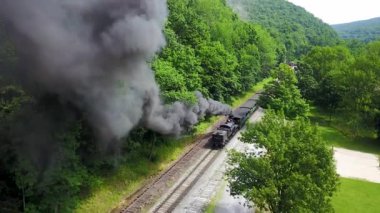 Bu güzel güneşli yaz gününde havada asılı duran kara dumanla birlikte hava kamerası yükseliyor..