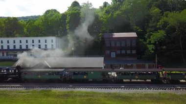 Hava kamerası, turistler boşalırken ve duman yığınından siyah dumanlar dökülürken trenin tam uzunluğunu gösteriyor..