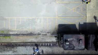 Hava kamerası aşağıya bakıyor ve siyah tren motorunun uzunluğunu değiştiriyor..