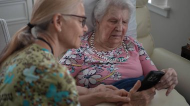 Mutlu hemşire huzurevinde yaşlı bir kadınla iletişim kurar. Fotoğraflarını ve bilgilerini telefonundan paylaşır. Bağlantı ve anılarını destekler..