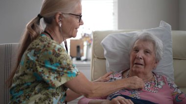 Hoş bir ziyaret sırasında, bir hemşire yaşlı bir kadının hayati organlarını kontrol eder ve huzur evinde neşeli bir konuşma yapar..