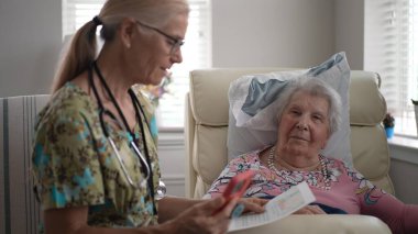 Bir hemşire, yaşlı bir kadının yaşam tesisinde hoş bir sohbete girişirken hayati organlarını kontrol eder. Bağlantı ve bakım anlarını paylaşıyorlar..