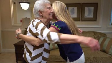 Yaşlı kadın gülümserken sarışın kadın içeri giriyor ve sarılıyorlar..