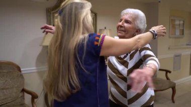 Yaşlı kadın gülümserken sarışın kadın içeri giriyor ve sarılıyorlar..