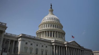 Birleşik Devletler Kongre Binası 'nın, açık mavi gökyüzü ile güneşli bir günde, Washington, DC' deki hükümet binası bayrağı yarıya indirilmiş durumda..