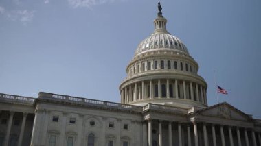 Birleşik Devletler Kongre Binası 'nın, açık mavi gökyüzü ile güneşli bir günde, Washington, DC' deki hükümet binası bayrağı yarıya indirilmiş durumda..