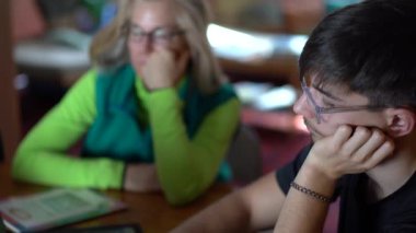 Odaklanma değişimi. Bilgisayar ekranından anneye bakarak okul ödevleri hakkında konuşarak..